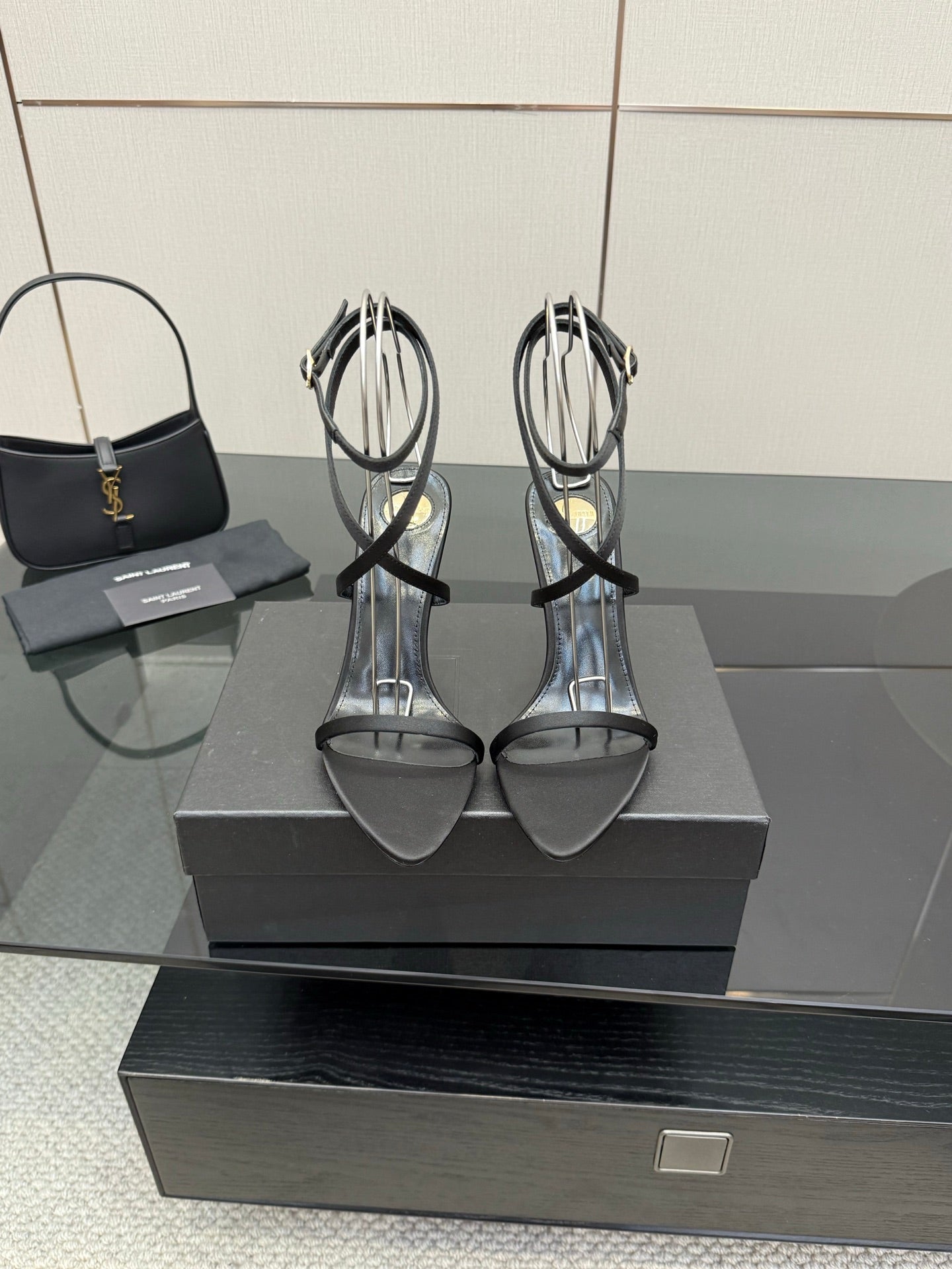 Silver strappy heeled sandals with thin straps and gold-tone heel accents