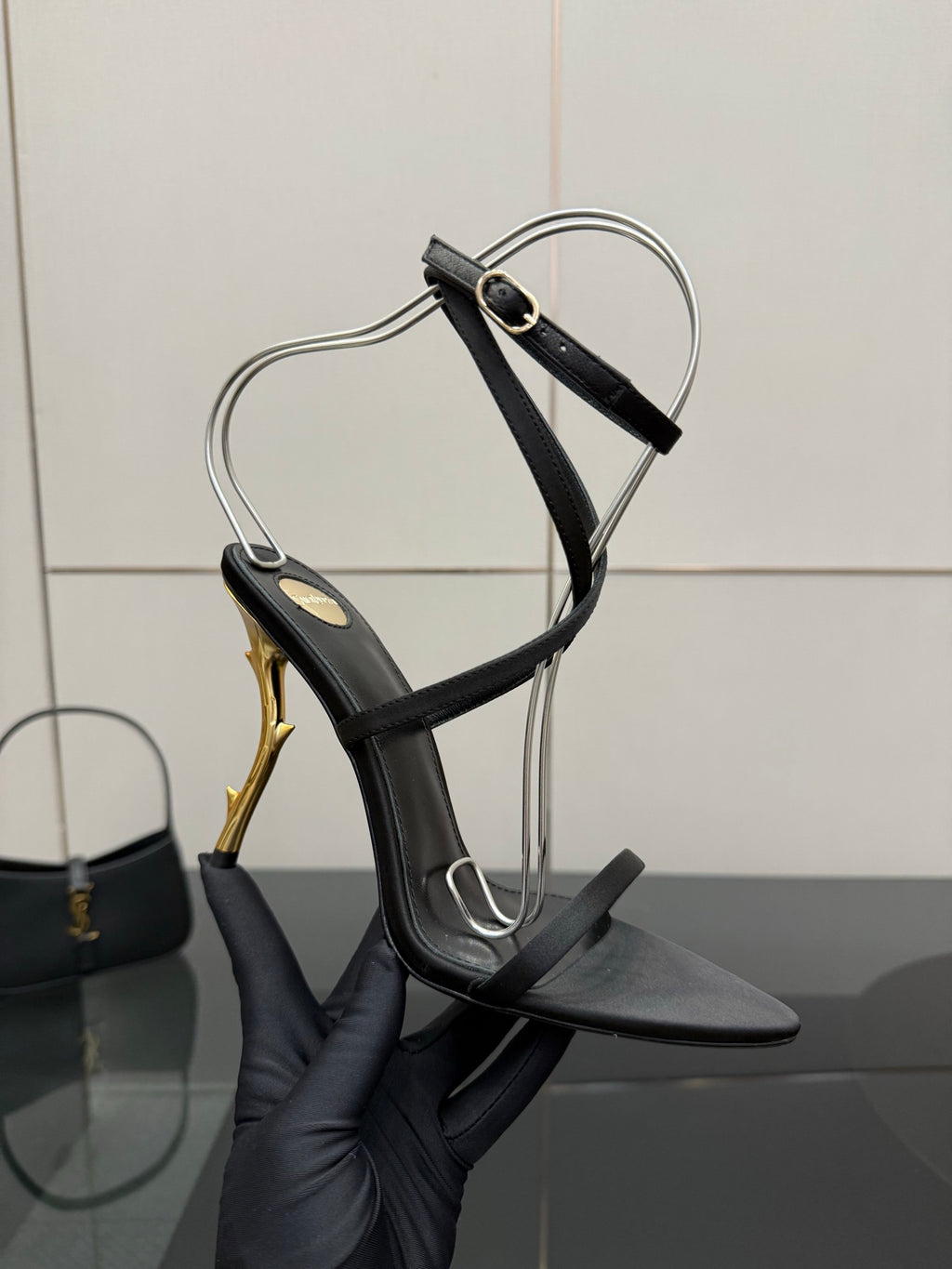 Black strappy heeled sandal with ankle wrap and gold-tone stiletto heel