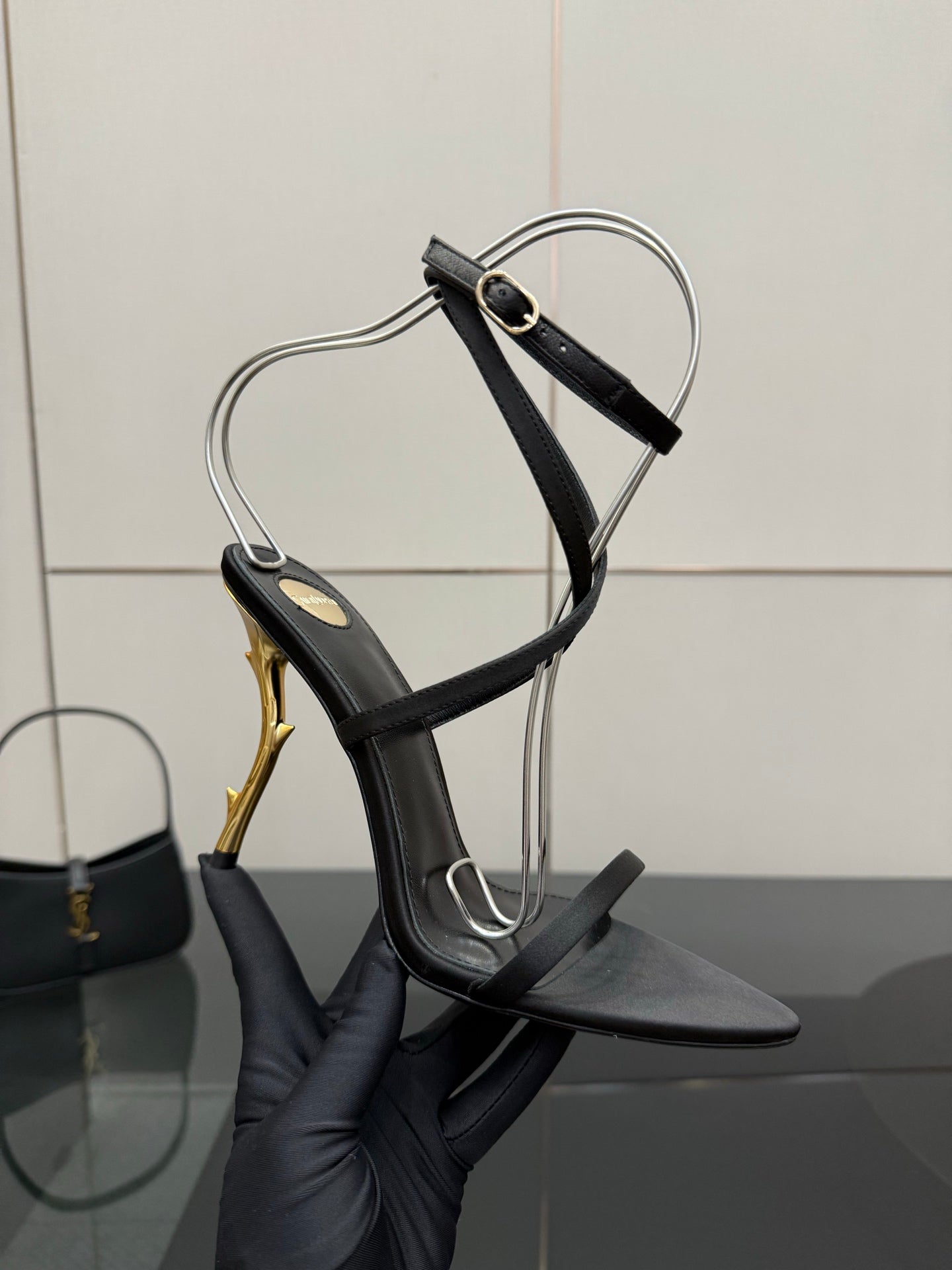 Black strappy heeled sandal with ankle wrap and gold-tone stiletto heel