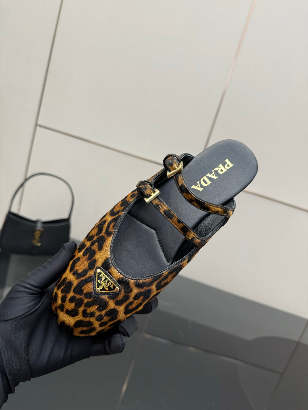 Prada leopard-print flats with ankle strap, showing interior lining and sole