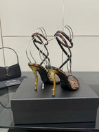 YSL women’s leopard-print heeled sandals with black crisscross straps and gold-tone stiletto heels