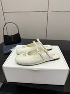 Women's Prada white leather flats with double buckle straps and logo patch on upper