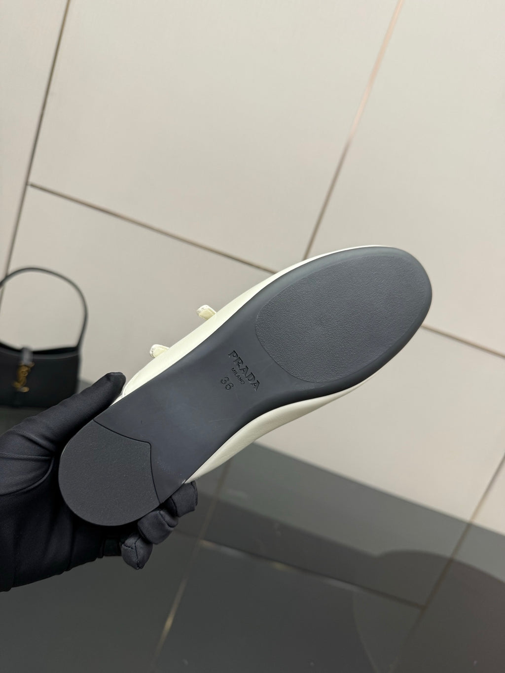 Women's Prada flat sole view, dark rubber outsole with curved tread profile