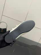 Women's Prada flat sole view, dark rubber outsole with curved tread profile