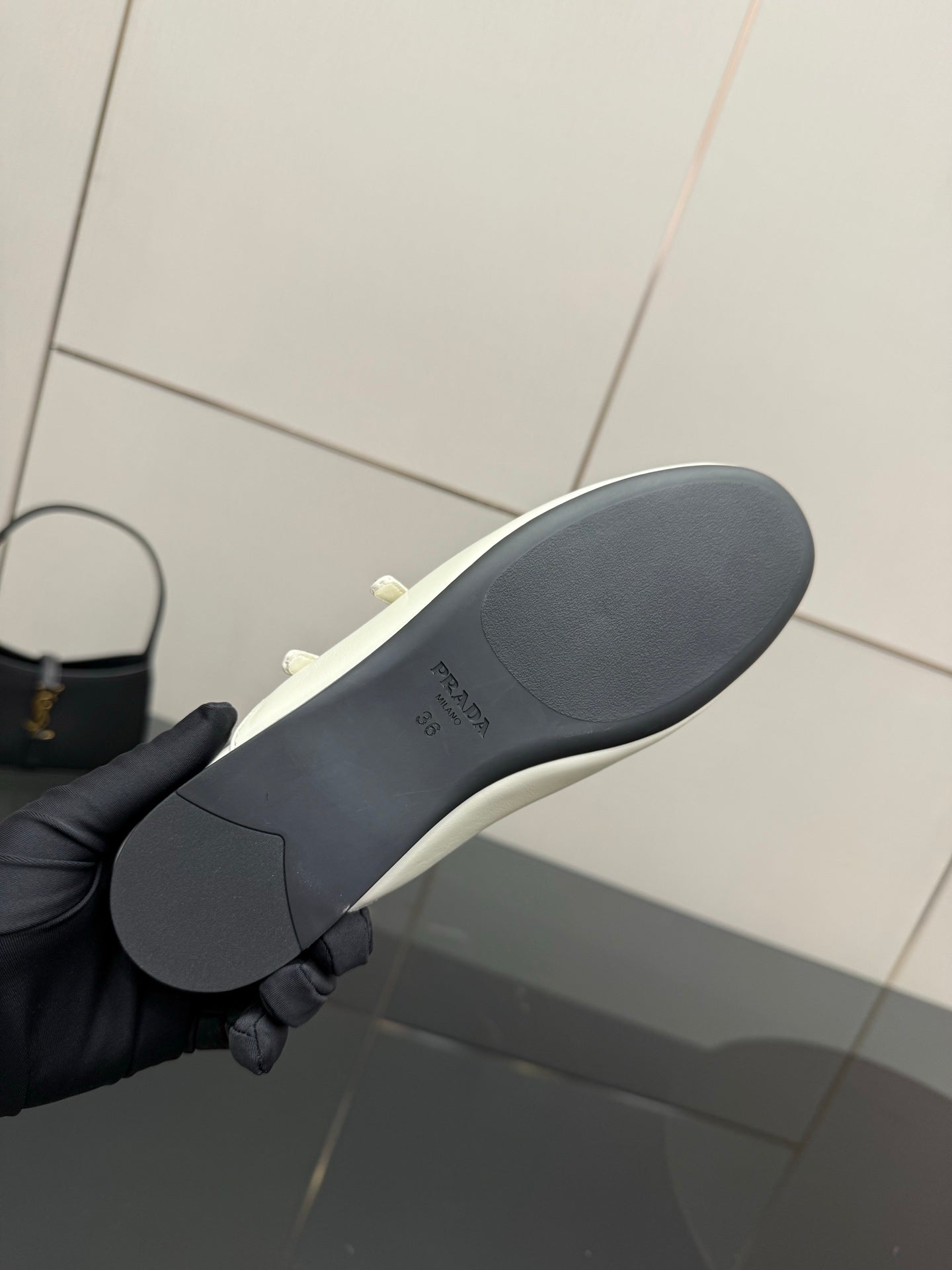 Women's Prada flat sole view, dark rubber outsole with curved tread profile