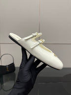 Women's Prada white leather flat shoe held up, double buckle strap and logo patch