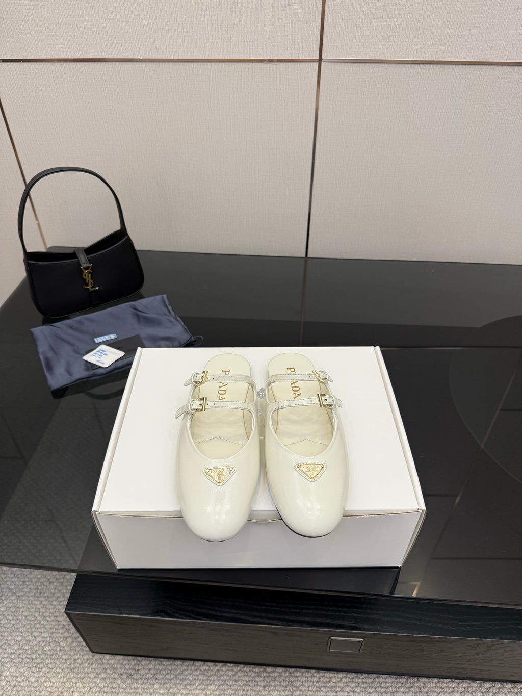 Women's Prada white leather flats with double buckle straps and triangular logo detail
