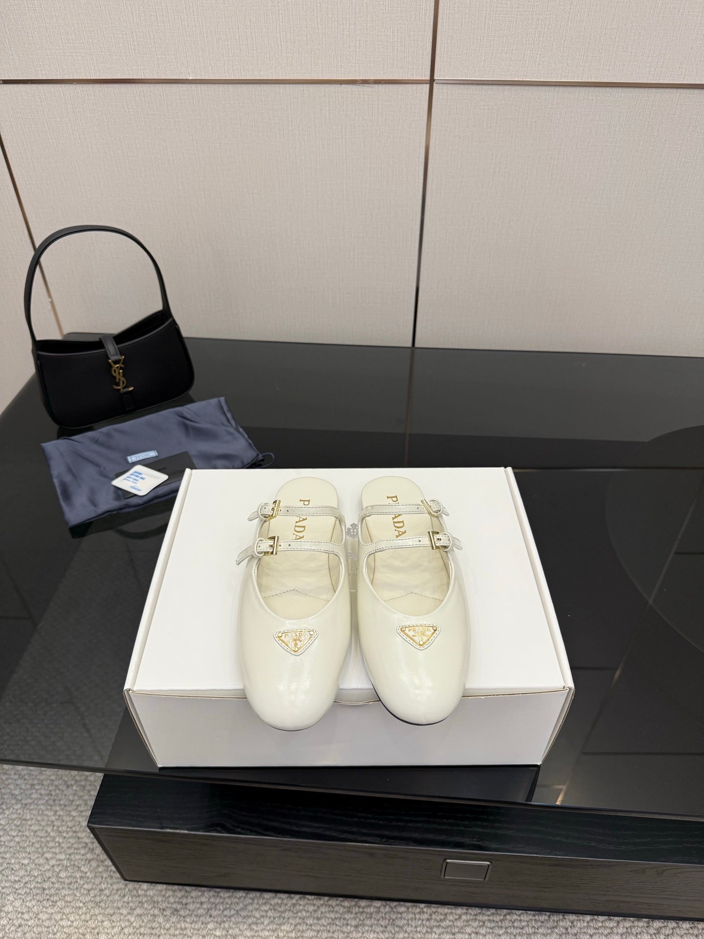 Women's Prada white leather flats with double buckle straps and triangular logo detail