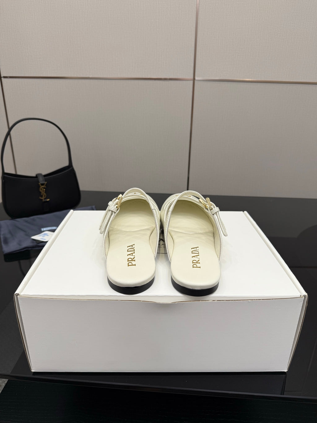 Women's Prada white leather slide flats with double buckle strap, shown on display box