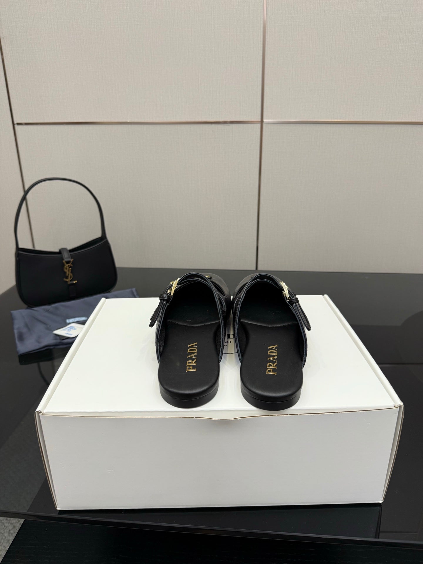 Women's black Prada slip-on shoes with logo on footbed and back strap