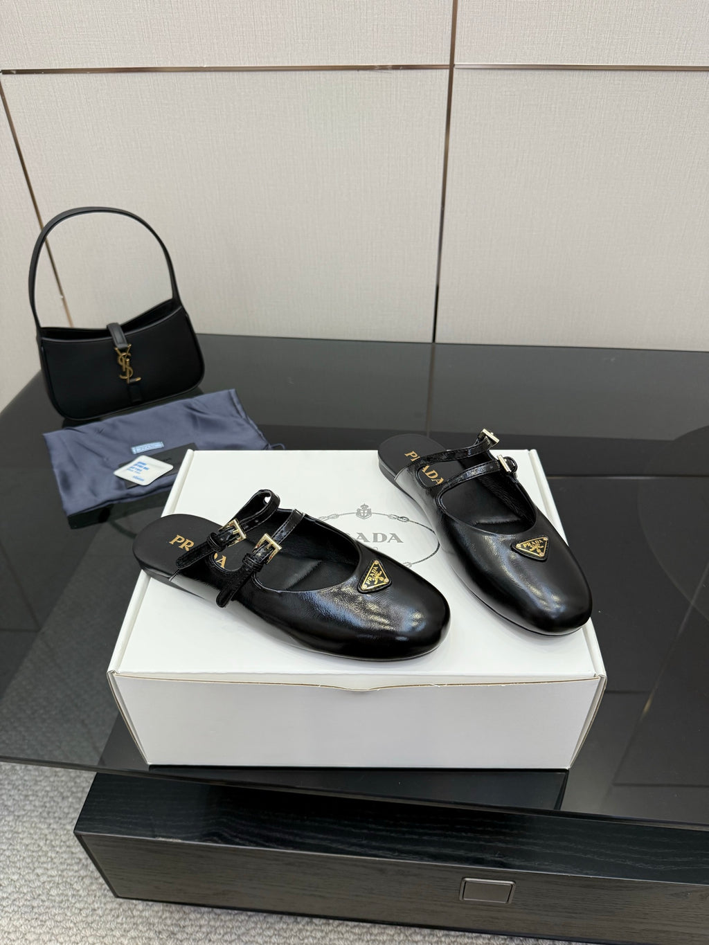 Women's black leather Prada slip-on shoes, gold-trimmed strap and logo tag