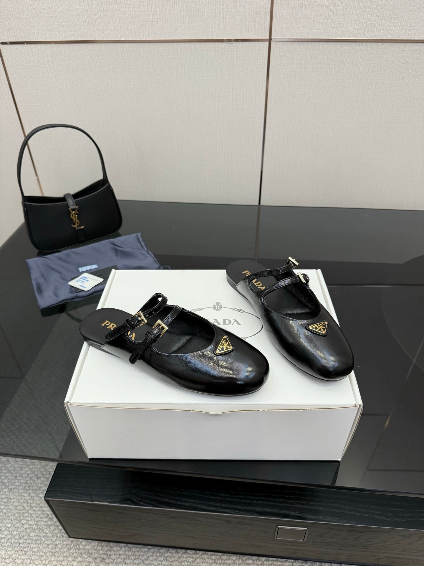 Women's black leather Prada slip-on shoes, gold-trimmed strap and logo tag