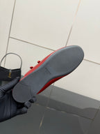 Red leather mule flat with gray outsole, heel underside shown