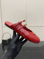 Red leather mule flats with gold buckle hardware and pointed toe
