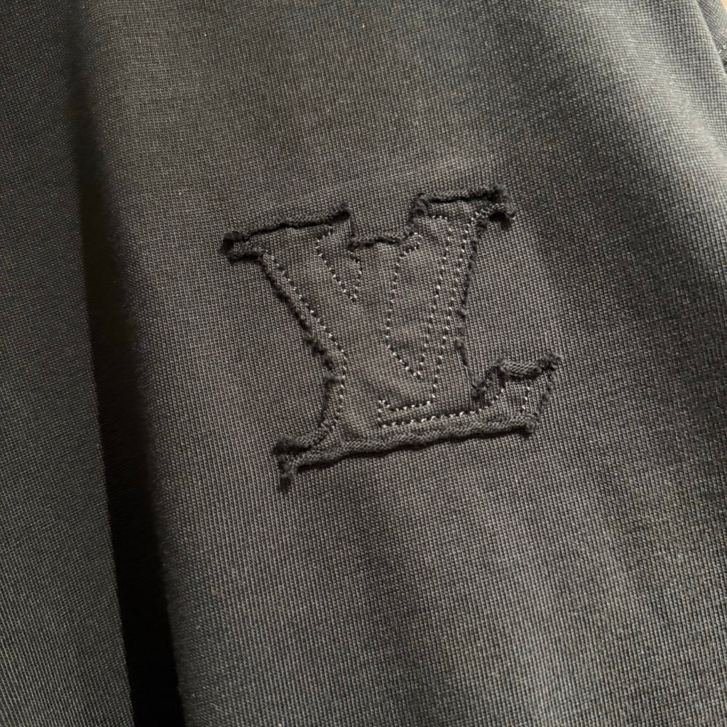 Louis Vuitton dark embroidered LV emblem on black T-shirt fabric