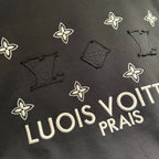 Louis Vuitton black T-shirt detail with white flower icons and partial 'LOUIS' lettering