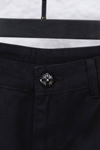 Black cargo pants waistband button closure with decorative flower-style rivet