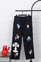 Black cargo pants with cross-style appliques in blue, white, and leopard print