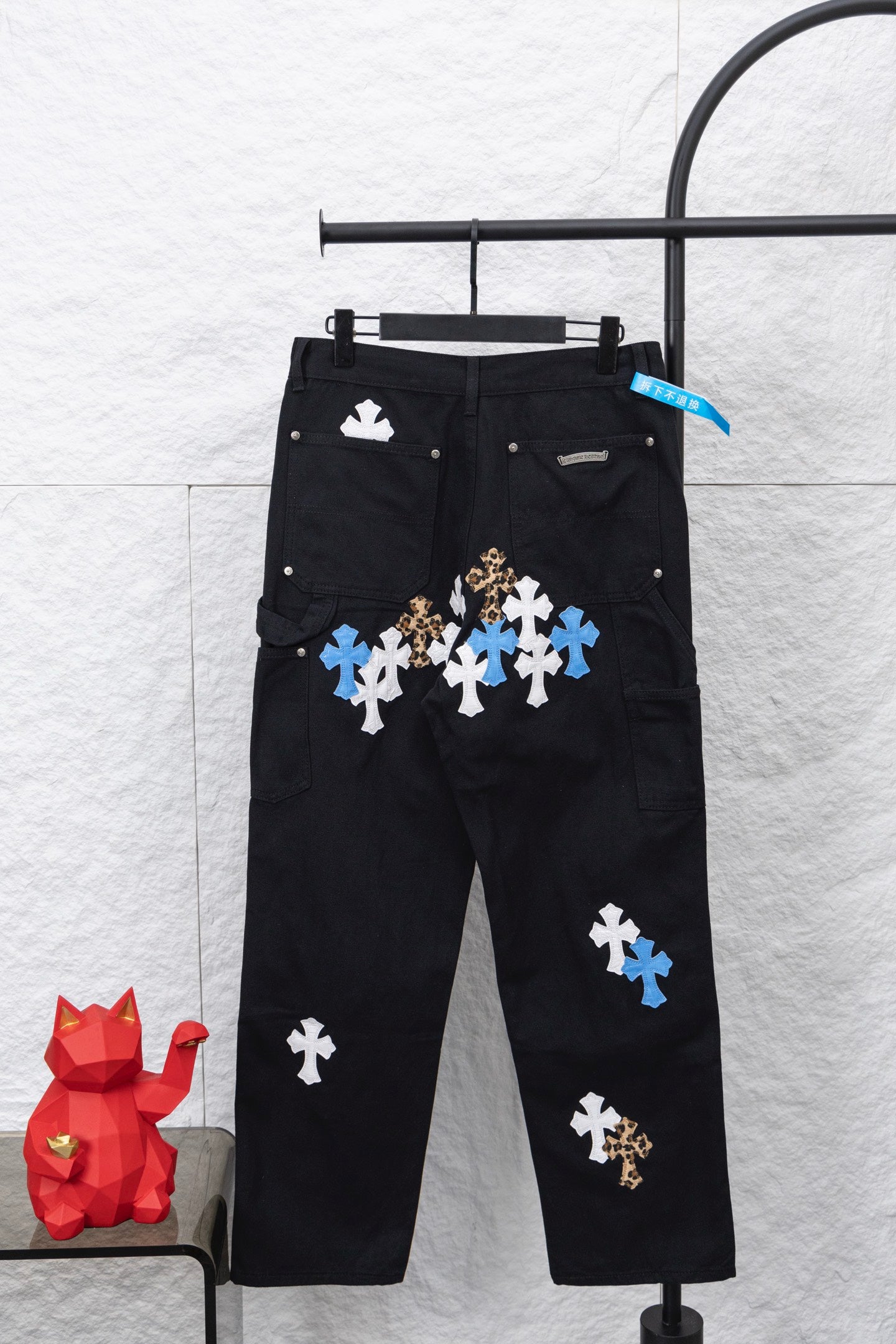 Black cargo pants with front and side cross appliques in blue and white