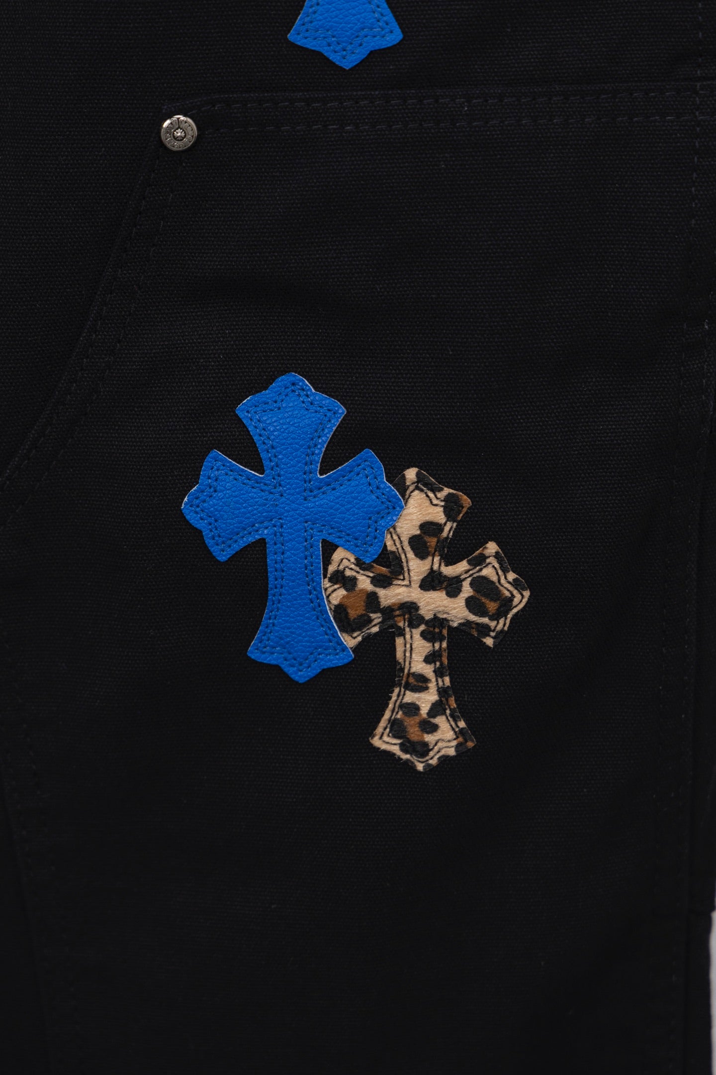 Black pants with blue cross and leopard print patch on leg