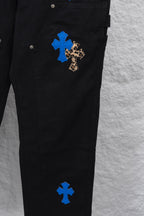 Black cargo pants side close-up with leopard-and-blue cross patch at thigh