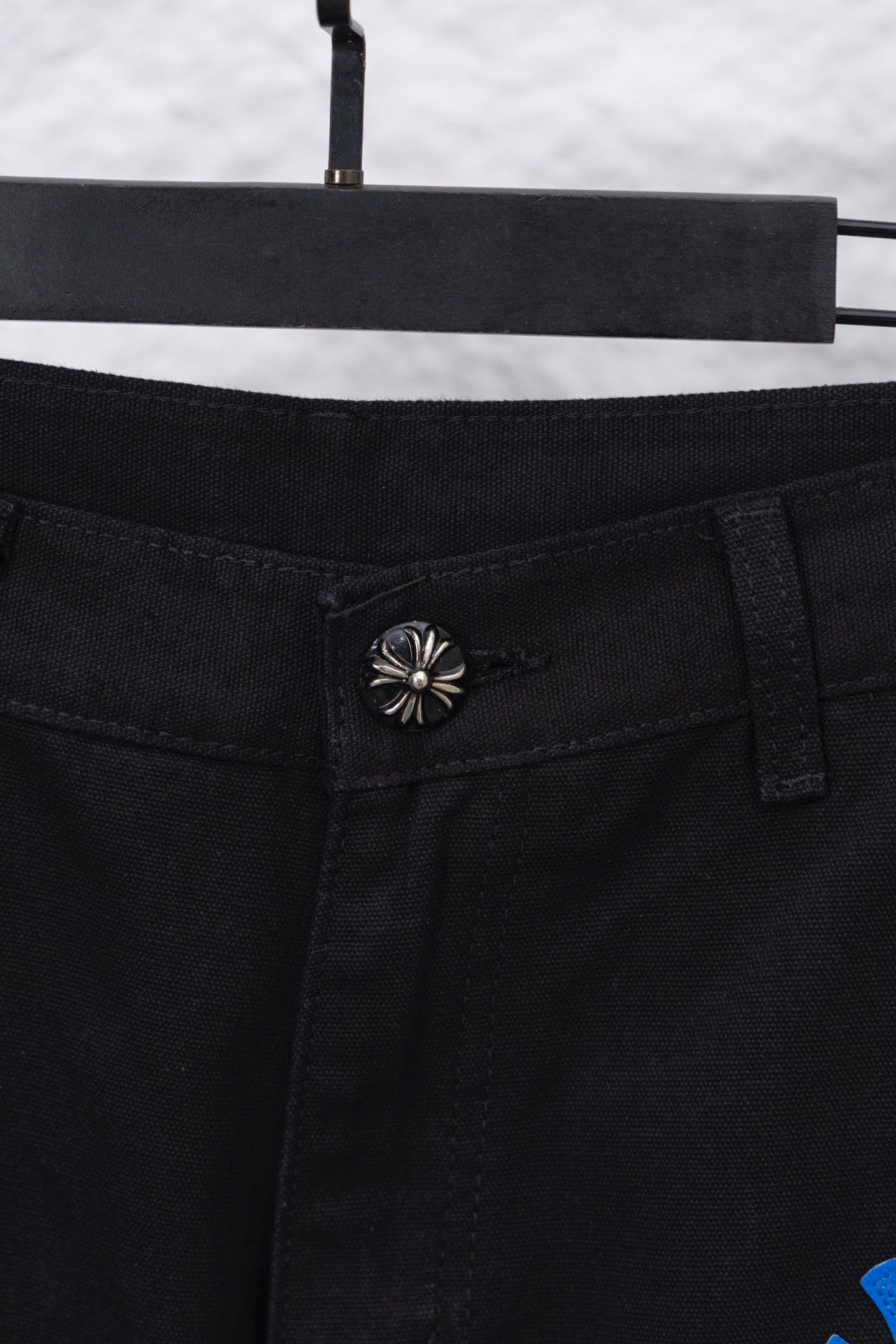 Black pants waistband close-up with decorative snap button