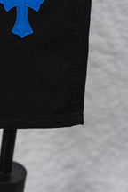 Black pants hem close-up with blue cross patch
