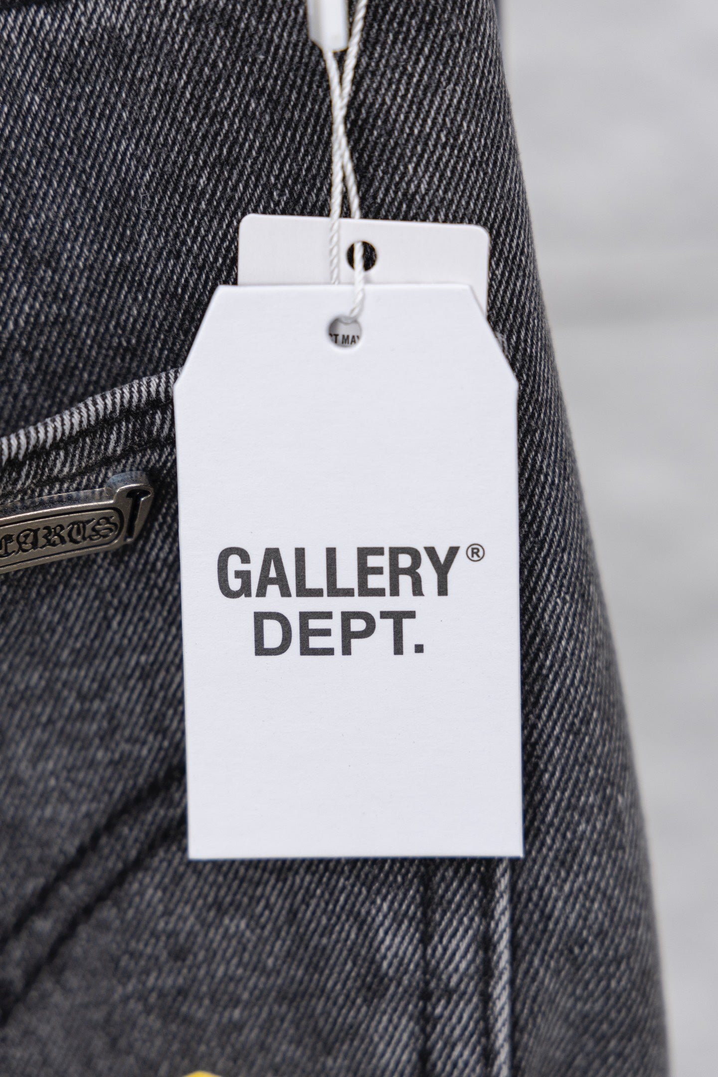 Clothing tag on denim pants reading “GALLERY DEPT.”