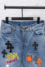 Light blue denim pants with front graphic patches, waistband view.
