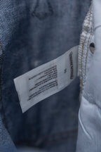 Chrome pants denim close-up with woven care label and metal button