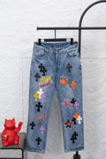 Light blue denim pants with colorful graphic patches, front view.