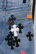 Light blue denim pants with black-and-white patch and orange tag, close-up.