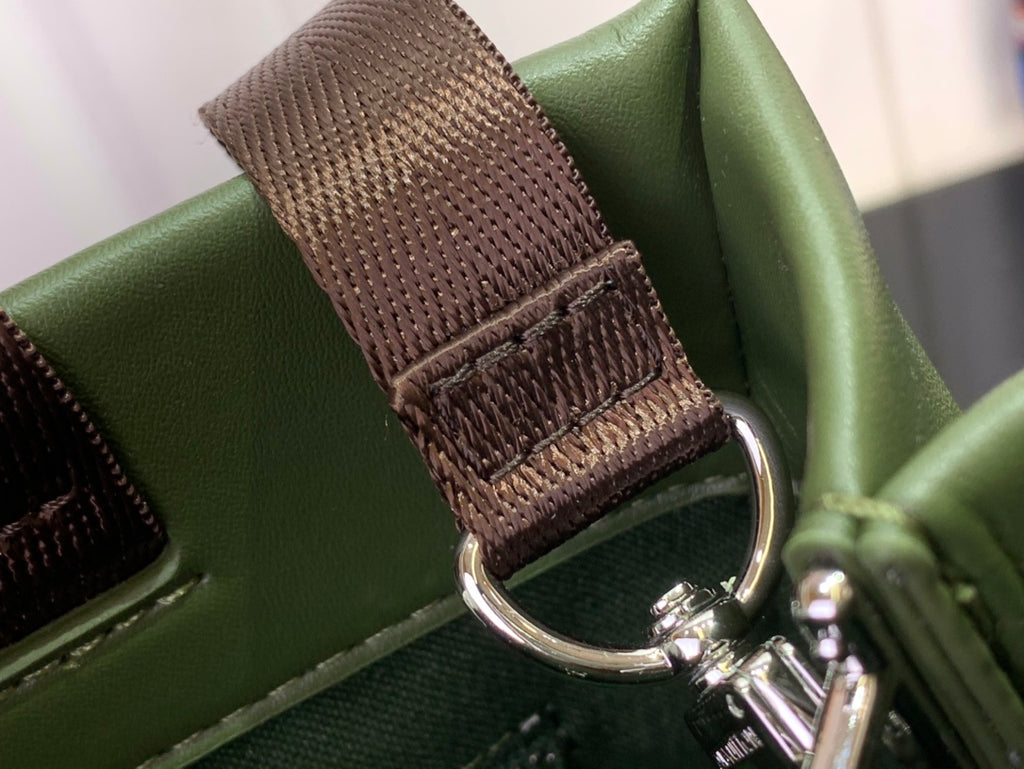 Louis Vuitton tote bag strap detail with brown woven section and metal hardware