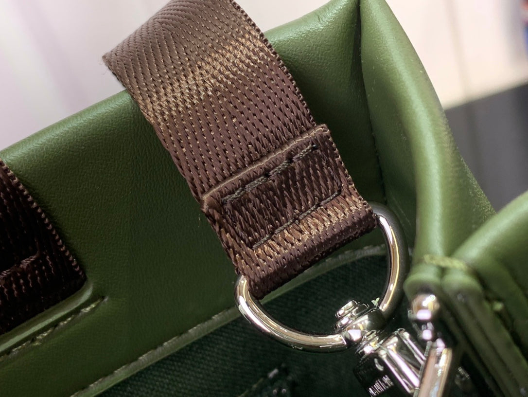 Louis Vuitton tote bag strap detail with brown woven section and metal hardware