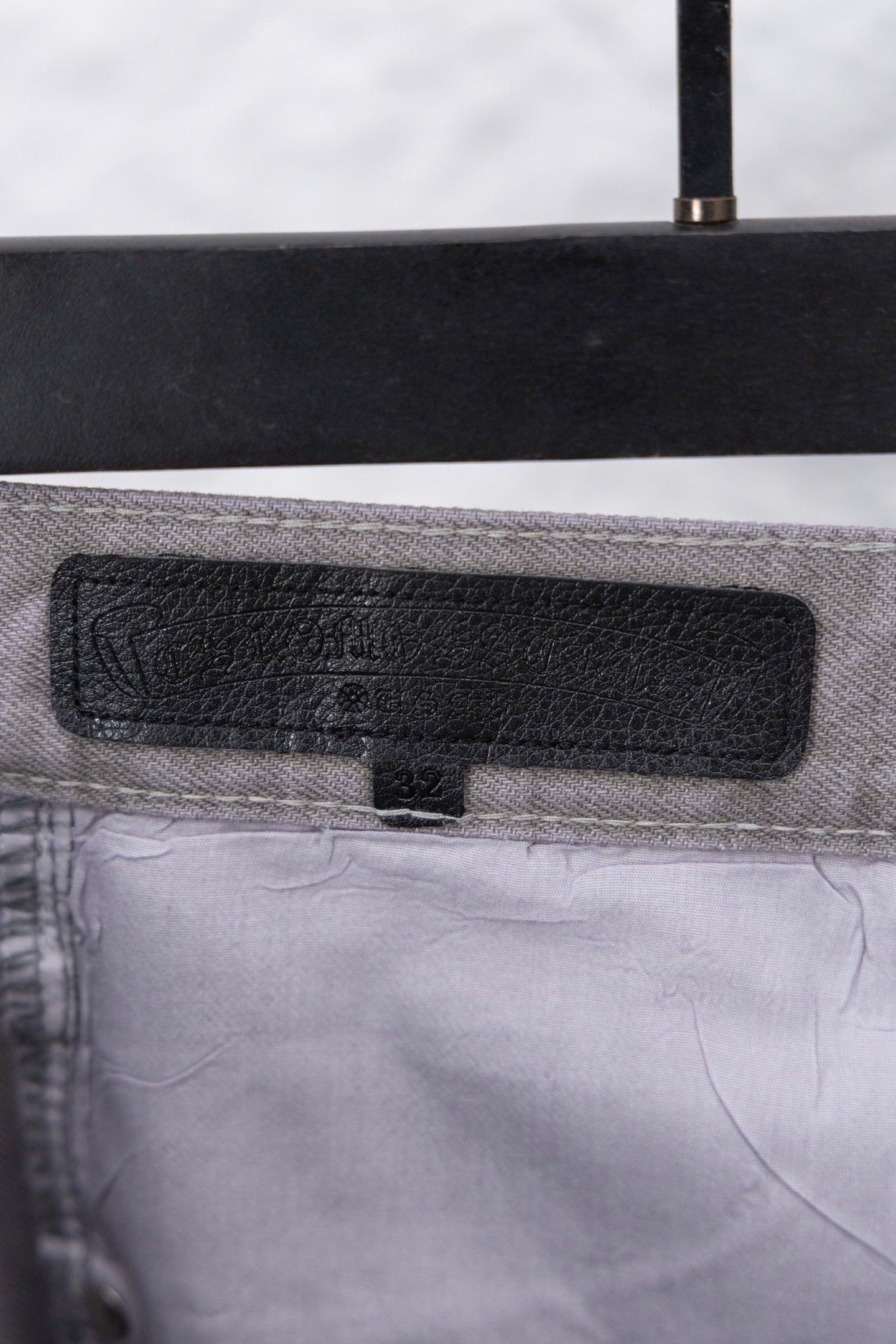 Black fabric label on waistband of Chrome pants