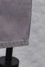 Light gray denim pant leg hem with stitched edge, close-up