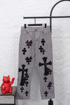 Light gray denim pants with black cross and bow-like appliques, front view