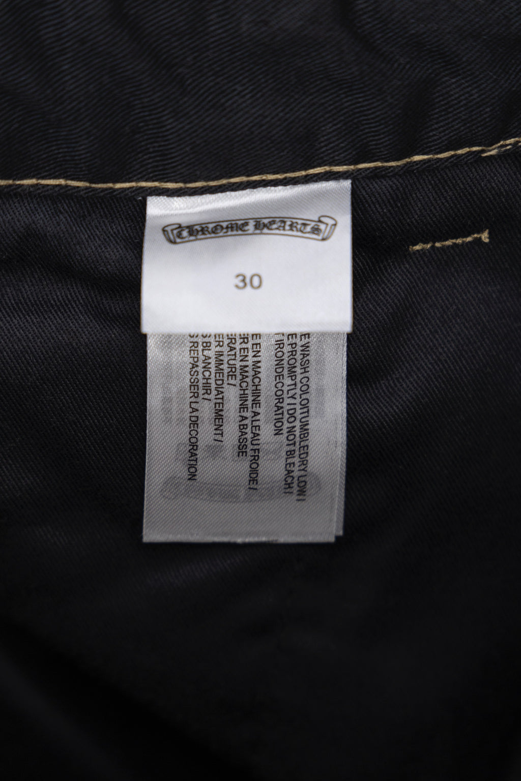 Black pants label and size tag with fabric care and measurement text