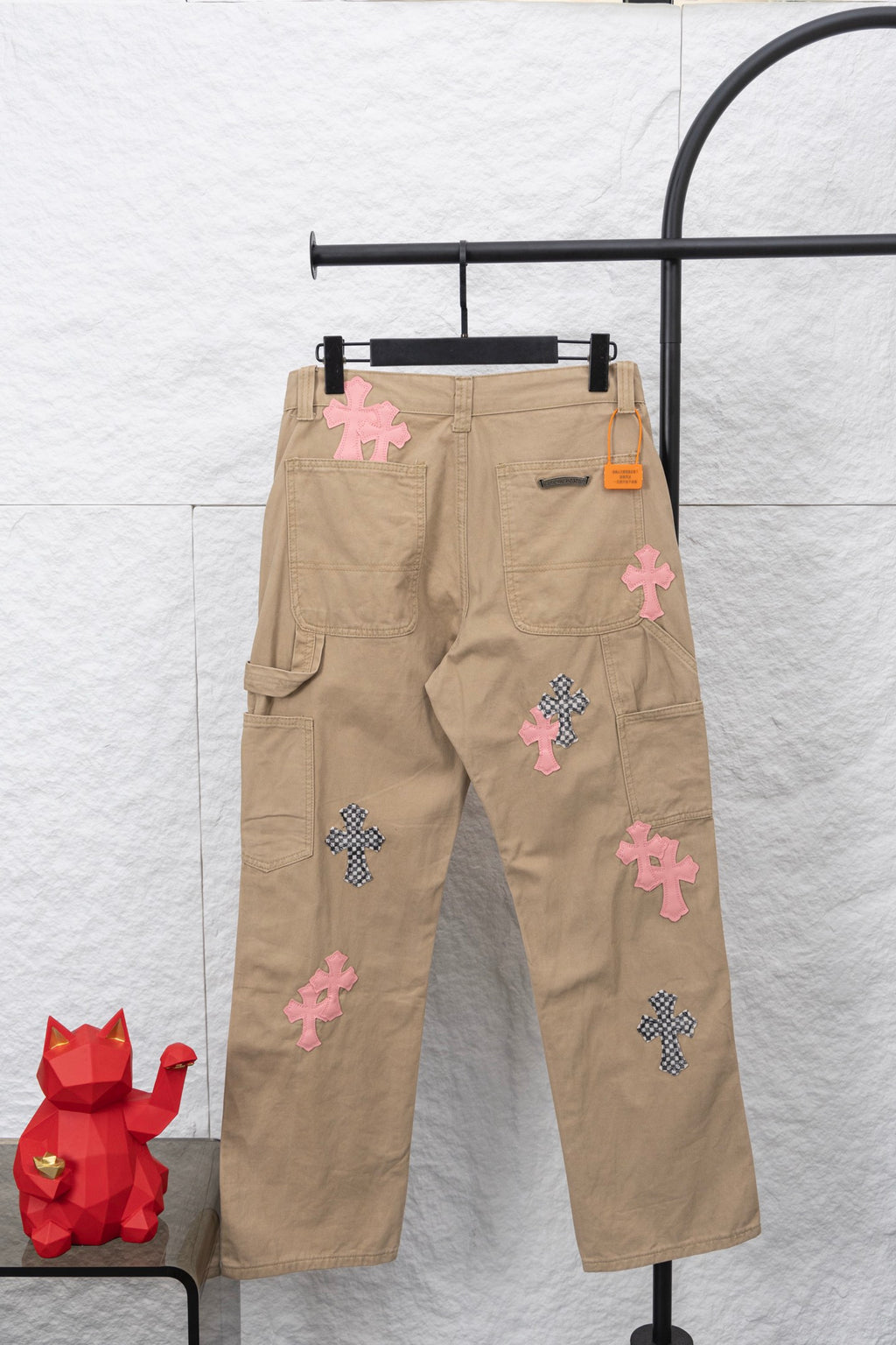 Tan cargo pants with multiple pink and patterned cross appliques and side pockets