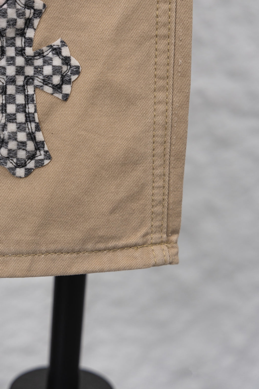 Beige pant leg hem with visible stitching and folded cuff detail