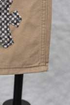 Beige pant leg hem with visible stitching and folded cuff detail