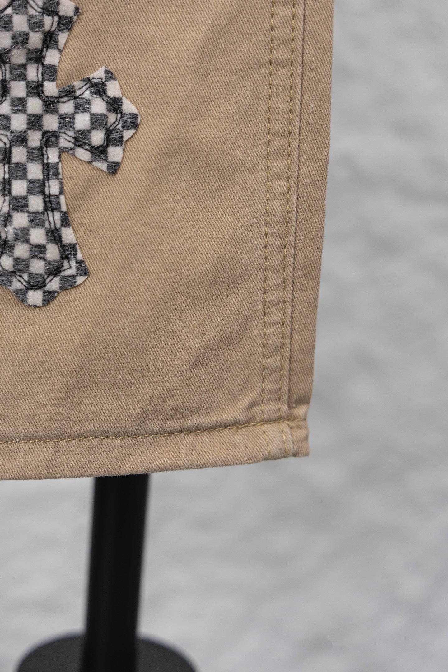 Beige pant leg hem with visible stitching and folded cuff detail