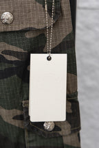 Camouflage pants with hanging white size tag and silver button at the waistband