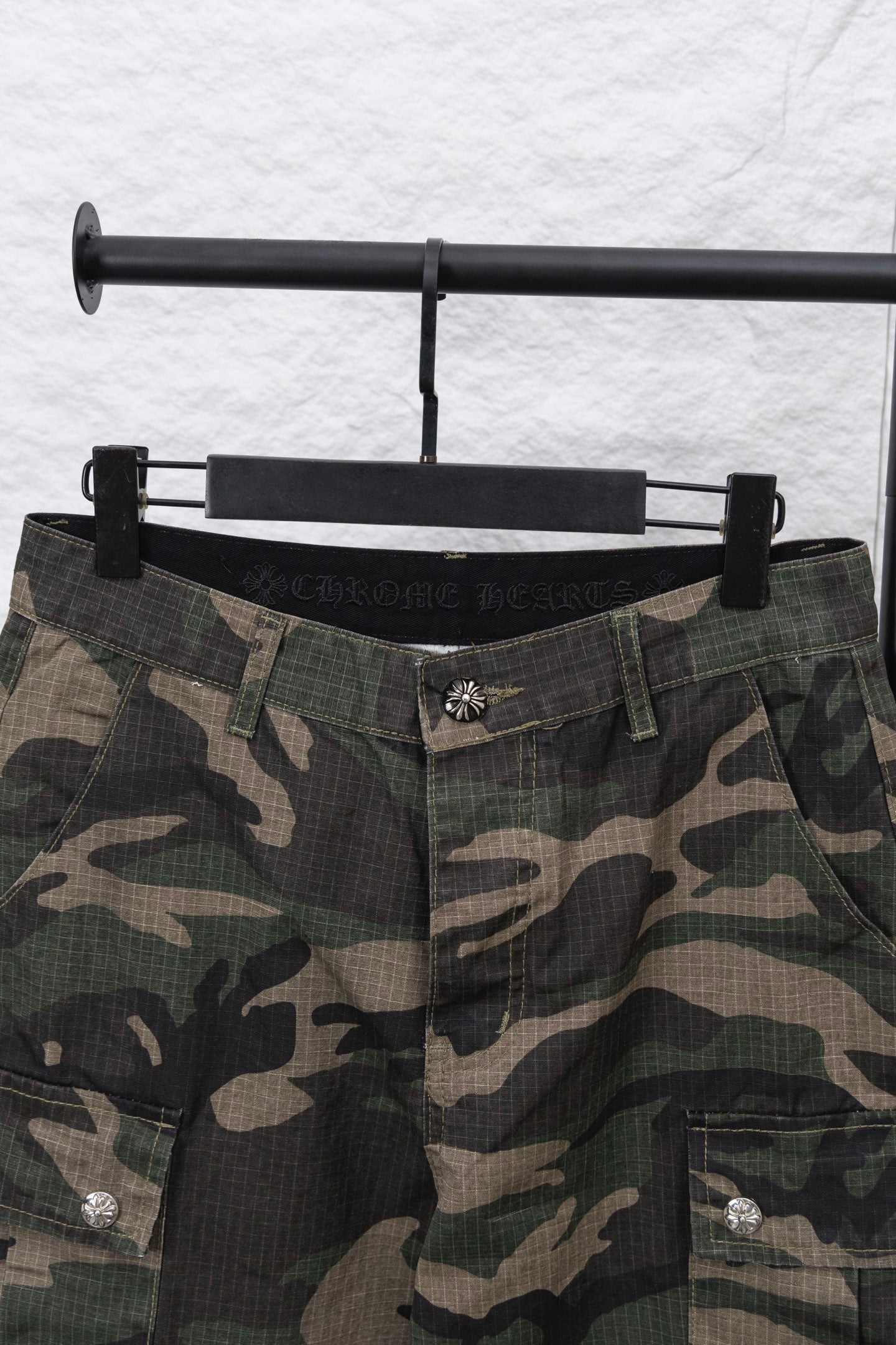 Camouflage pants waistband and front button detail with belt loops