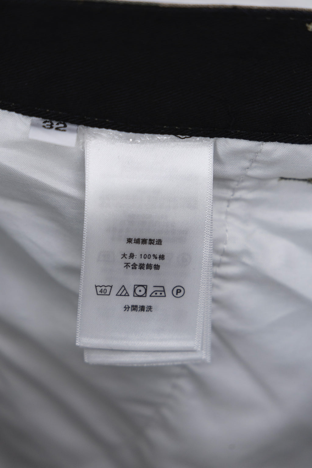 Inner label tag on camouflage pants with care and size information