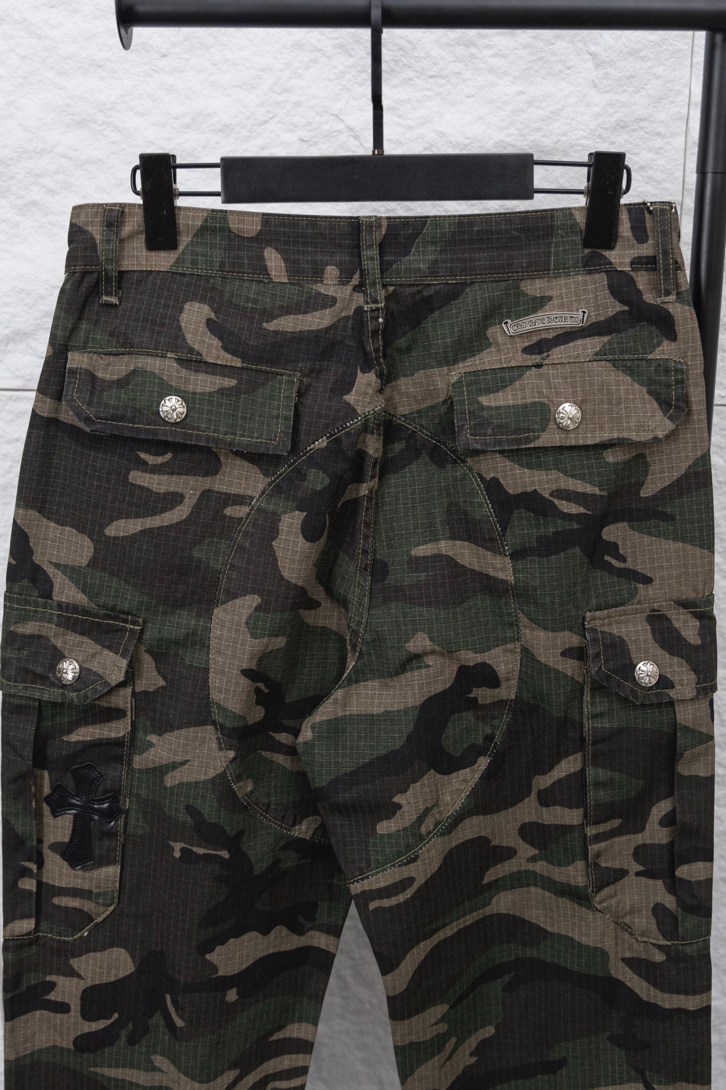 Camouflage pants front view with multiple cargo pockets and metal buttons