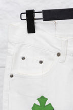 White denim pants front pockets with metal snaps and green cactus-style patch, close-up