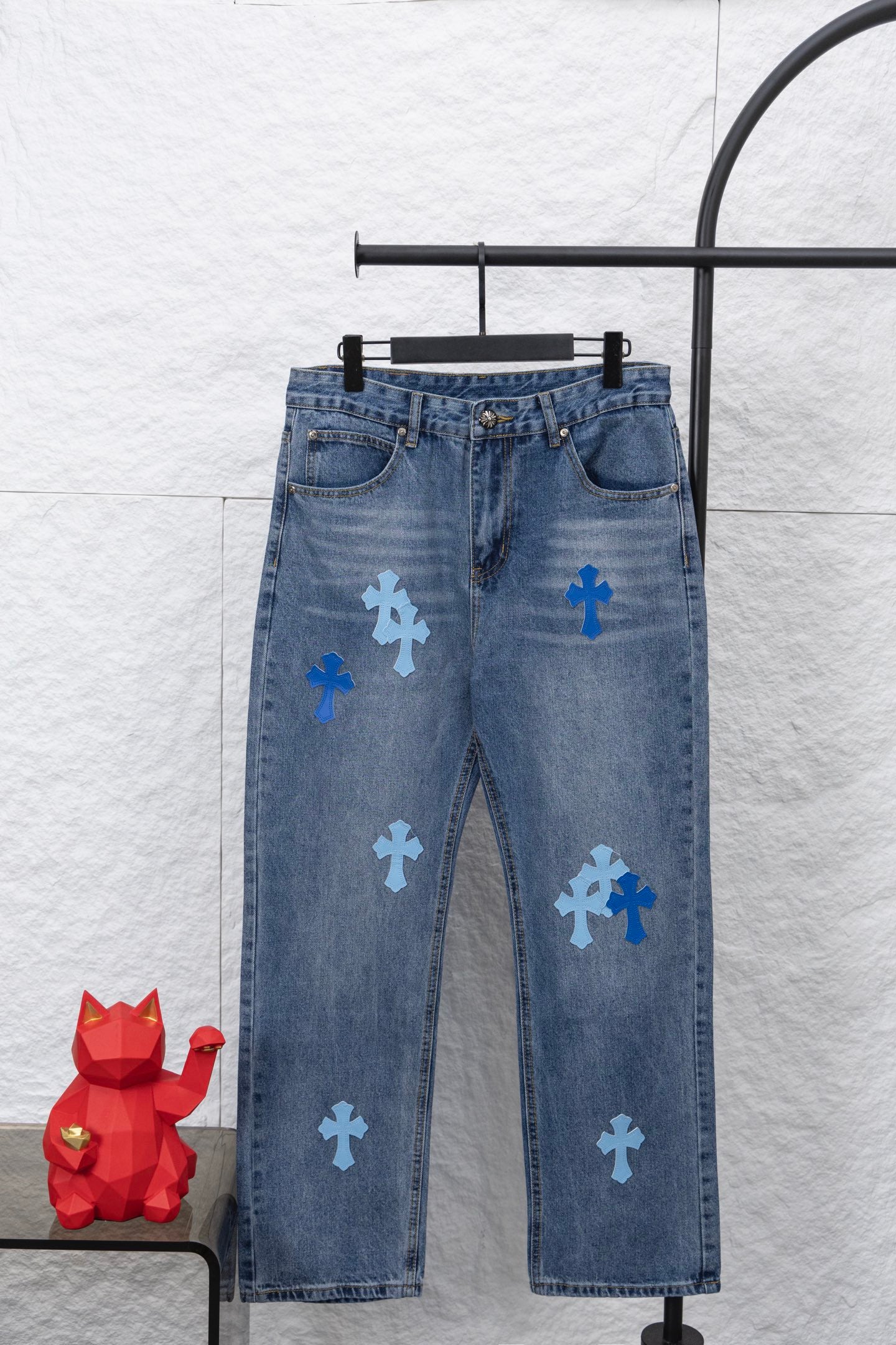 Light blue denim pants with multiple blue cross patches on the legs