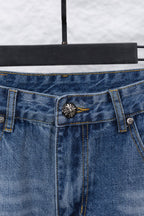 Light blue denim waistband with center button and decorative patch on pocket