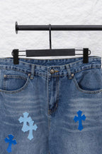Light blue denim pants with front pockets and scattered blue cross patches
